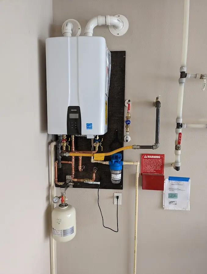 Professional plumber installing copper piping in a Needham home